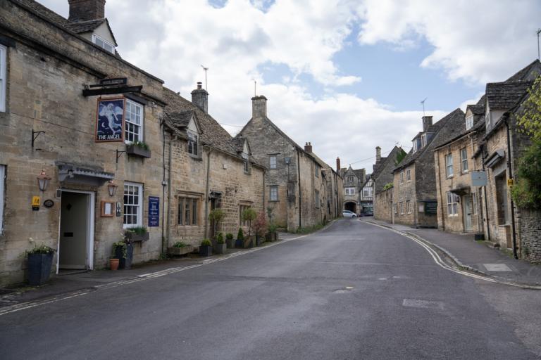 An ancient village street, with a pub in the foreground.